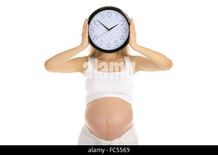 Schwangere Frau hält das runde Zifferblatt Stockfoto