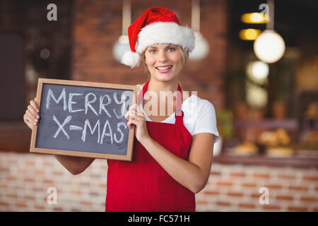 Hübsche Kellnerin mit einer Tafel Frohe Weihnachten Stockfoto