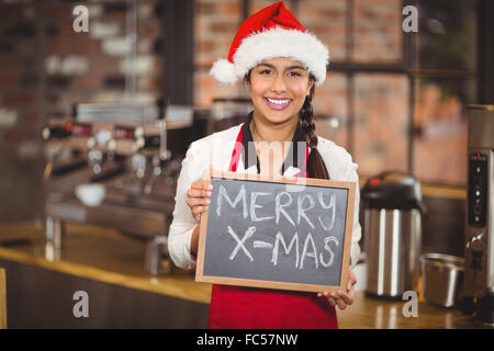 Hübsche Kellnerin mit einer Tafel Frohe Weihnachten Stockfoto