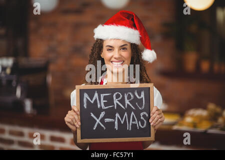 Hübsche Kellnerin mit einer Tafel Frohe Weihnachten Stockfoto