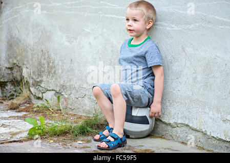 Junge sitzt auf einem ball Stockfoto