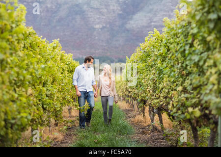 Junge glückliche Paar zu Fuß neben einander, während die Hand in Hand Stockfoto