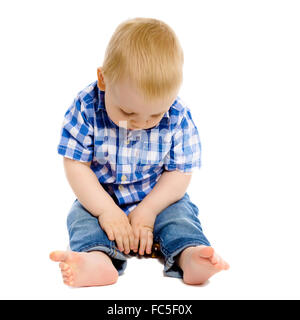 kleiner Junge in einem karierten Hemd und jeans Stockfoto