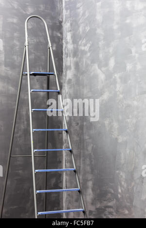 In der Ecke in der Nähe die unbemalte Wände Trittleiter Stand. Stockfoto