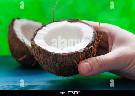 Kokosnuss-Hälften auf einem blau-grünen Hintergrund Stockfoto