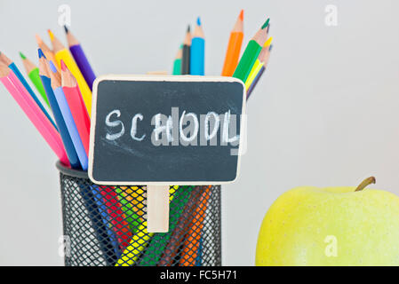 Gelber Apfel und Bleistifte in Halter Stockfoto