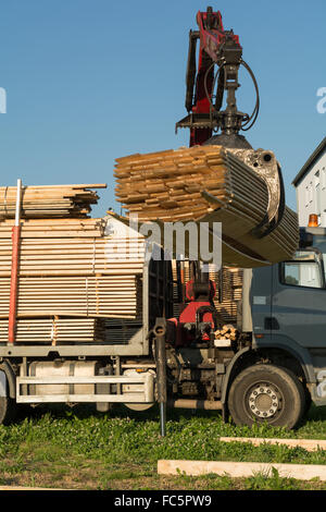 LKW-Kran hebt Holz Transporter Stockfoto