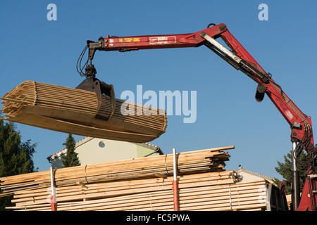 LKW-Kran hebt mit Greifer Holz Stockfoto