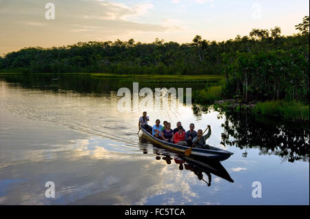 Menschen, die mit dem Kanu im Amazonasfluss in Ecuador, Südamerika, unterwegs sind Stockfoto