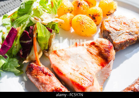 Fleisch, Bratkartoffeln und Salat. Stockfoto