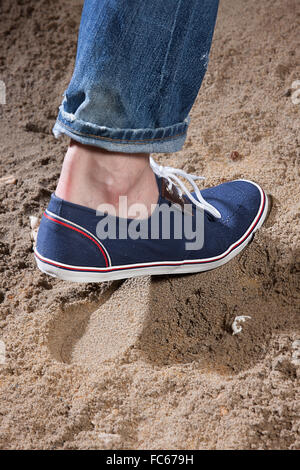 Mannes Beine und Fußabdruck im Sand Stockfoto