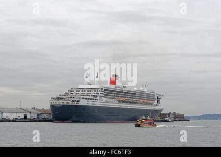 Cunard Kreuzfahrtschiff, Queen Mary 2, angedockt in Red Hook, Brooklyn, mit Red Hook Fähre vorbei. Stockfoto