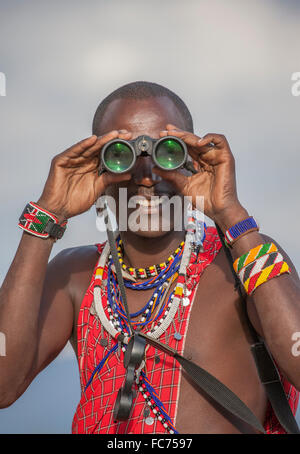 Schwarzer Mann in traditioneller Kleidung mit dem Fernglas Stockfoto