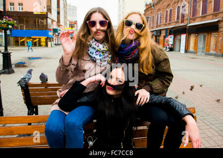 Kaukasischen Frauen posieren auf Bank Stockfoto