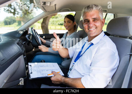 lächelnd senior männlichen Fahrlehrer in einem Auto mit Lernenden Fahrer geben Daumen oben Stockfoto