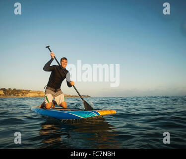 Kaukasischen Mann auf Paddel Board im Ozean Stockfoto