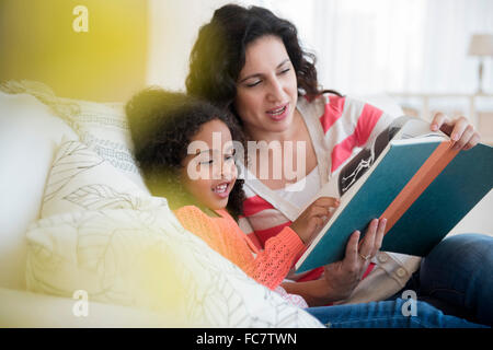 Mutter und Tochter auf Sofa lesen Stockfoto