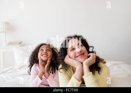 Mutter und Tochter Tagträumen auf Bett Stockfoto