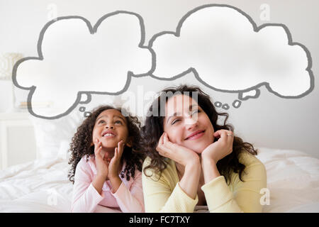 Mutter und Tochter denken auf Bett Stockfoto