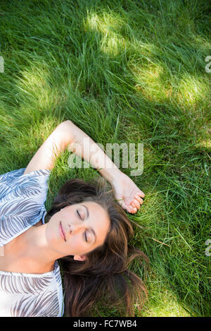 Kaukasische Frau Verlegung in Rasen Stockfoto