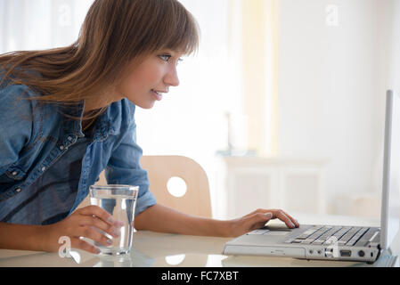 Gemischte Rassen Frau mit Laptop am Tisch Stockfoto