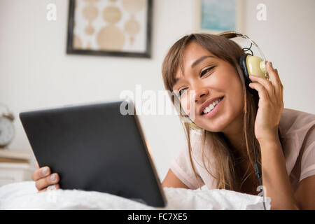 Gemischte Rassen Frau Kopfhörer anhören Stockfoto