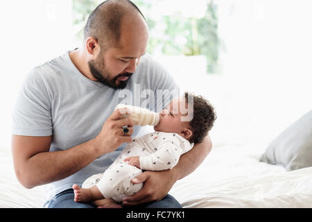 Vater mit der Flasche füttern Baby Sohn Stockfoto