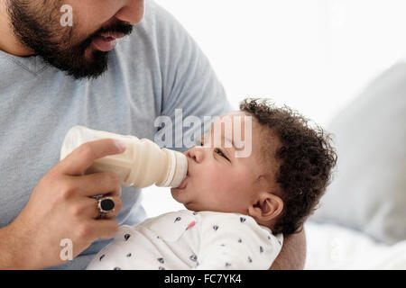 Vater mit der Flasche füttern Baby Sohn Stockfoto