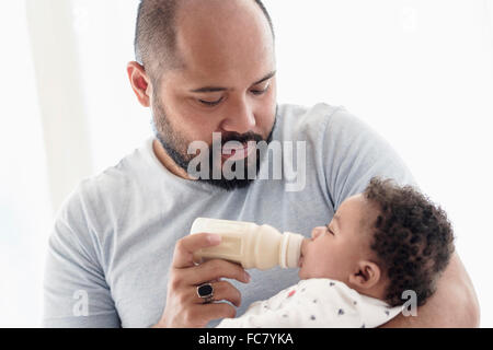Vater mit der Flasche füttern Baby Sohn Stockfoto
