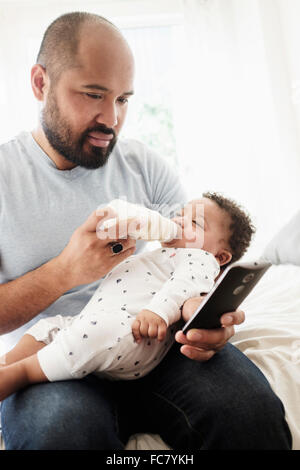 Vater Flasche Fütterung Baby Sohn und mit Handy