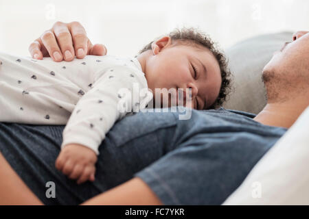 Vater und Baby Sohn schläft auf Bett Stockfoto