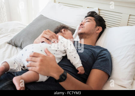 Vater und Baby Sohn schläft auf Bett Stockfoto