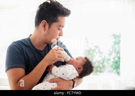 Vater mit der Flasche füttern Baby Sohn Stockfoto