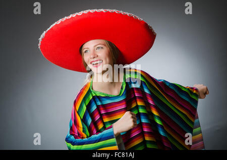 Mädchen im mexikanischen lebendige Poncho gegen grau Stockfoto