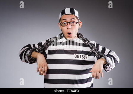 Jungen Gefangenen in Ketten gegen grau Stockfoto