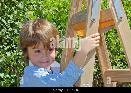 Der charmante junge auf Trittleiter Stockfoto