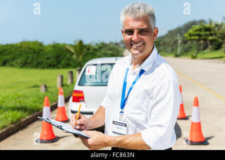 gut aussehend senior Fahrlehrer in Zwischenablage schreiben Stockfoto