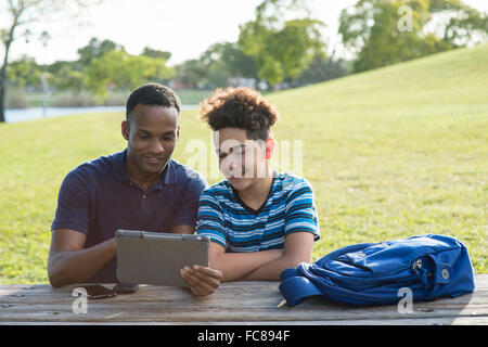 Vater und Sohn mit digital-Tablette im park Stockfoto