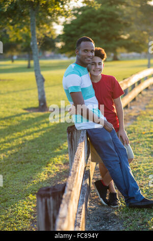 Vater und Sohn umarmt am Zaun Stockfoto