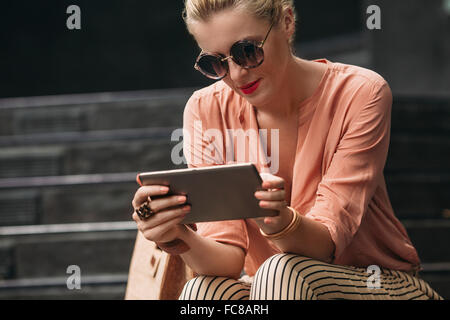 Kaukasische Frau mit digital-Tablette auf Treppen Stockfoto