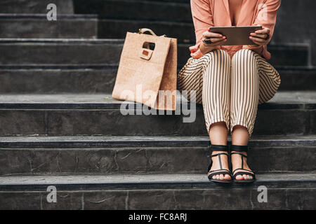 Kaukasische Frau mit digital-Tablette auf Treppen Stockfoto