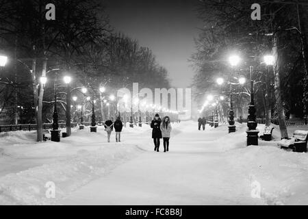 Menschen gehen auf eine beleuchtete Boulevard in der Nacht im Winterschnee wie reich verzierte Straßenlaternen beleuchten den Weg Stockfoto