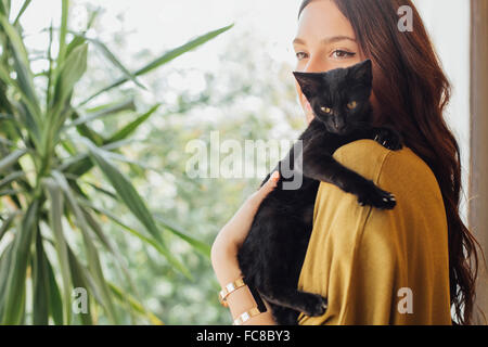 Kaukasische Frau Holding Kätzchen Stockfoto