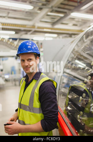 Porträt zuversichtlich Arbeiter stützte sich auf Maschinen in der Fabrik Stockfoto