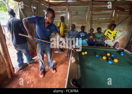 Einem jungen Mann beim Billard in der Hütte, Jinja, Uganda, Afrika Stockfoto