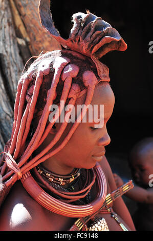 EPUPA, NAMIBIA - Mai 2011: Eine unbekannte Himba Frau, mit farbigen in rotem Ocker, Posen für die Fotografen in einem Himba-Dorf am Körper Stockfoto