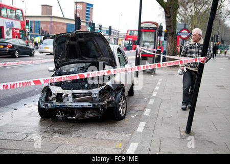 London, UK, 21. Januar 2016. Ein Ford-Auto Feuer fing außerhalb Tesco Express auf Holz grün High Road am frühen Morgen.  Rauch immer noch obwohl der verbrannten Motor und die Schriftart des Autos. Polizei abgesperrt das ausgebrannte Auto mit Polizei Klebeband. Bildnachweis: Dinendra Haria/Alamy Live-Nachrichten Stockfoto