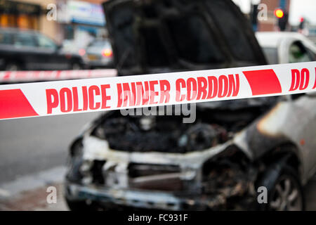 London, UK, 21. Januar 2016. Ein Ford-Auto Feuer fing außerhalb Tesco Express auf Holz grün High Road am frühen Morgen.  Rauch immer noch obwohl der verbrannten Motor und die Schriftart des Autos. Polizei abgesperrt das ausgebrannte Auto mit Polizei Klebeband. Bildnachweis: Dinendra Haria/Alamy Live-Nachrichten Stockfoto