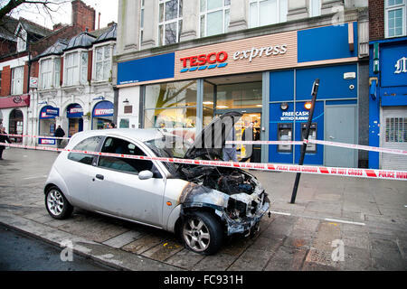 London, UK, 21. Januar 2016. Ein Ford-Auto Feuer fing außerhalb Tesco Express auf Holz grün High Road am frühen Morgen.  Rauch immer noch obwohl der verbrannten Motor und die Schriftart des Autos. Polizei abgesperrt das ausgebrannte Auto mit Polizei Klebeband. Bildnachweis: Dinendra Haria/Alamy Live-Nachrichten Stockfoto