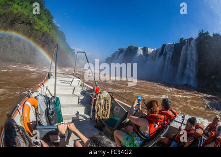 Touristen nehmen eine Bootstour an der Basis des Wasserfalls, Iguazu Falls National Park, UNESCO-Weltkulturerbe, Misiones, Argentinien Stockfoto